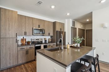 A kitchen with a large island with a counter top and a sink